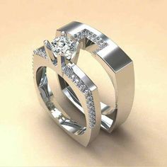 two wedding rings with diamonds on top of each other, one is white gold and the other is silver