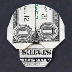 an origami skull made out of one dollar bill with the word genius written on it