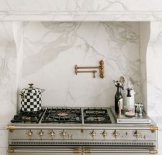 a stove top oven sitting inside of a kitchen next to a wall mounted faucet