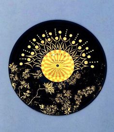 a black and yellow plate with gold designs on the top, against a blue background