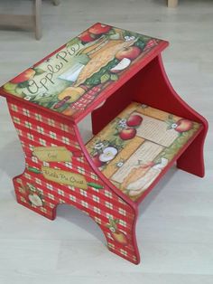 a wooden step stool with an apple theme painted on the side and writing underneath it