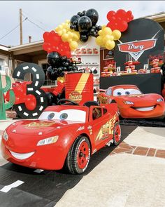 cars are parked in front of a birthday party with balloons and streamers on display