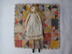 a doll is laying on top of a quilt