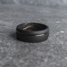 a black and gold ring sitting on the ground