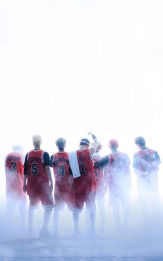 a group of men standing next to each other in front of a foggy sky