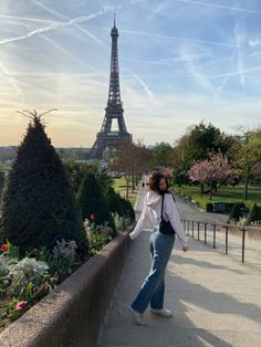 a woman standing in front of the eiffel tower with her hand on her hip