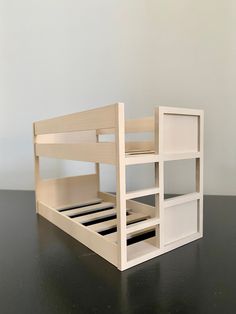 a toy bunk bed sitting on top of a black table