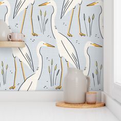 the wallpaper in this kitchen is painted with white and yellow pelicans on blue