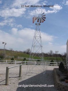 a windmill sitting on top of a gravel field