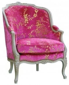 a pink and silver chair with gold designs on the arm rests against a white background