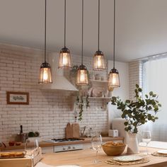 a kitchen with white brick walls and wooden counter tops, hanging lights over the island