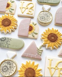 cookies decorated with sunflowers and letters are arranged on a white tablecloth that says, i love you