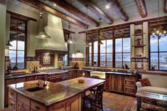 a large kitchen with wooden cabinets and marble counter tops, along with an island in the middle