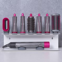 an assortment of different types of hair brushes and combs sitting on a shelf next to each other