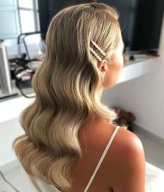 a woman with long blonde hair is sitting in front of a mirror