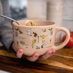 a person holding a coffee mug with food on it