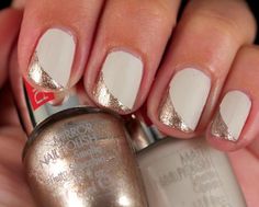 a woman's hand with white and silver manicures holding a bottle of nail polish