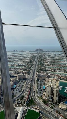 the view from inside an airplane looking down on a highway and buildings in the distance