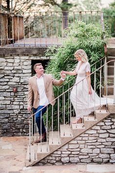 a man and woman walking up some stairs