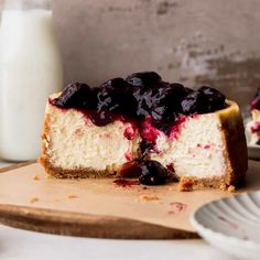 a piece of cheesecake with blueberry topping on a cutting board