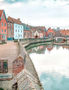 a river running through a small town next to tall brick buildings on either side of it