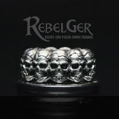 a silver ring with skulls on it and the words rebelger written in white lettering