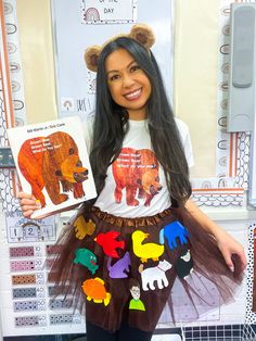 a woman holding up a book in front of her face and wearing a skirt with bears on it