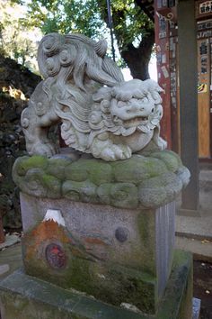 a stone lion statue sitting on top of a cement block