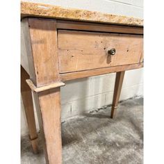 an old wooden table with a drawer on one side and two drawers on the other