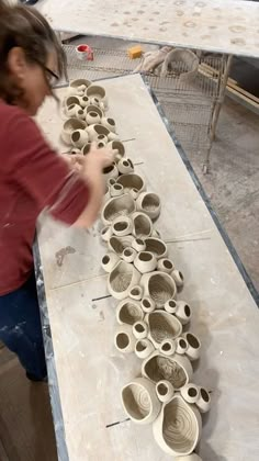 a woman is making bowls out of clay