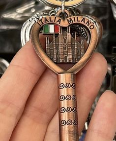 a person is holding a key to their heart shaped keychain with the italian flag on it