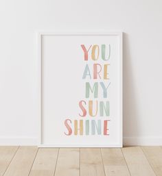 a white framed poster with the words you are my sun shine in pastel colors