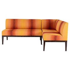 an orange and yellow striped couch sitting on top of a wooden frame