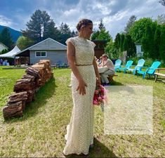 a woman in a wedding dress standing on the grass