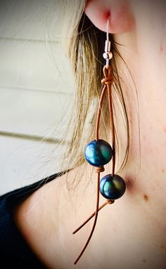 a close up of a person wearing some kind of earring with pearls on it