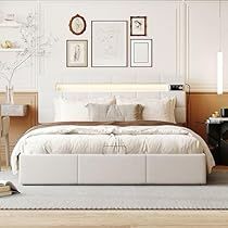 a white bed sitting in a bedroom on top of a hard wood floor next to a table