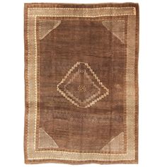 an old rug with brown and beige colors on the bottom, it has a diamond shaped design