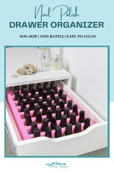 a drawer is filled with black bottles and pink trays on the bottom shelf in front of a white wall