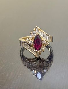 DeKara Designs Classic A ring my father Setrag Karadolian designed and made himself over 30 years that is back in fashion today! Beautiful Art Deco Ruby and Diamond Ring Handmade By A True Artist. Metal- 14K Yellow Gold, .583 Stones- 1 Natural Marquise Shaped Ruby Red in Color 0.85 Carats, 14 Baguette Diamonds, 4 Marquise Diamonds, 4 Round Diamonds, G-H Color VS1-VS2 Clarity 1.15 Carats. Handmade 14K Yellow Gold Marquise Ruby Baguette, Marquise, and Round Diamond Engagement Ring. This ring featu Luxury Marquise Cut Ruby Ring Fine Jewelry, Diamond Ring With Ruby Side Stones, Ruby Marquise Engagement Ring, Ruby Ring With Diamonds, Art Deco Ruby Engagement Ring, Art Deco Gemstone Ring, Ruby Engagement Ring Art Deco, Ruby Art Deco Ring, Wedding Ring Art Deco