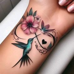 a humming bird with flowers on its arm