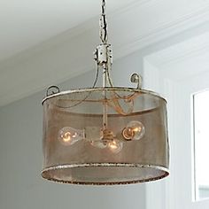 a chandelier hanging from the ceiling in a room with white walls and windows