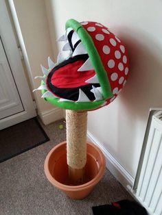 a red and white mushroom hat sitting on top of a cat tree