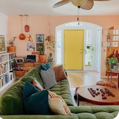 a living room filled with furniture and a yellow door in the back drop off from the wall