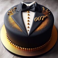 a black and gold birthday cake with a bow tie on it's lapel