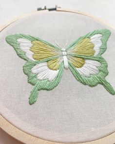 a green and white butterfly sitting on top of a piece of fabric with the words sale in shop below it