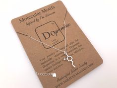 "Show your love through science with a Sterling Silver Dopamine Molecule pendant! Dopamine is the neurotransmitter and hormone that causes feelings of pleasure, addiction, desire and love. This pendant is inspired by the molecular structure of Dopamine and makes a great gift for Valentine's Day or any occasion inspired by love! You can choose to customize this with a birthstone charm. Choose your color in the drop-down menu. 🔬For other science themed jewelry, please check out my main shop page Dopamine Molecule, Psychology Gifts, Molecule Necklace, Science Jewelry, Science Themes, Molecular Structure, Weight Workout, Science Gifts, Art Carte