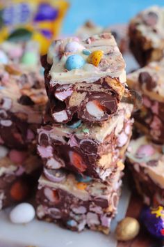 several pieces of chocolate candy bar stacked on top of each other with easter eggs in the background