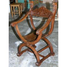 an old wooden chair sitting on top of a cement floor next to a table and chairs