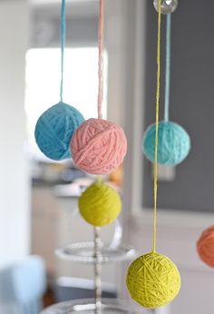 three balls of yarn are hanging from strings in the shape of balls on top of each other