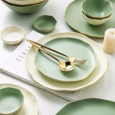 a table topped with green plates and goldware